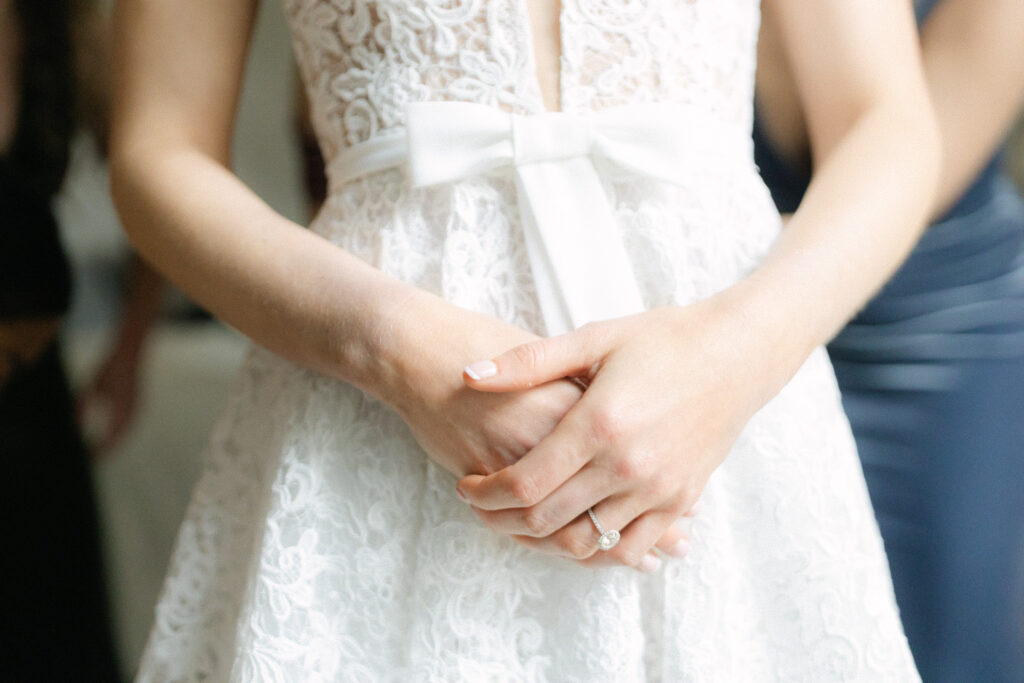 Bridal Gown Detail with Bow and Engagement Ring Close-up detail of a bride’s gown with a bow and her engagement ring as she gets ready on the wedding day