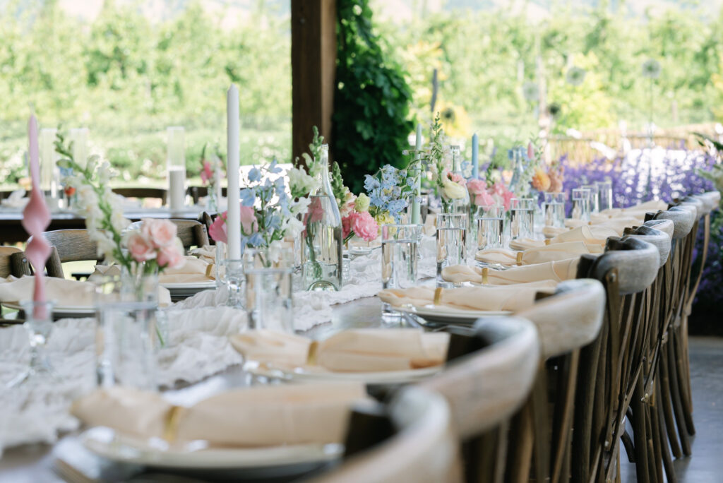 Spring Wedding Tablescape with Lush Greenery Spring wedding tablescape featuring seasonal florals and abundant greenery woven throughout the table design